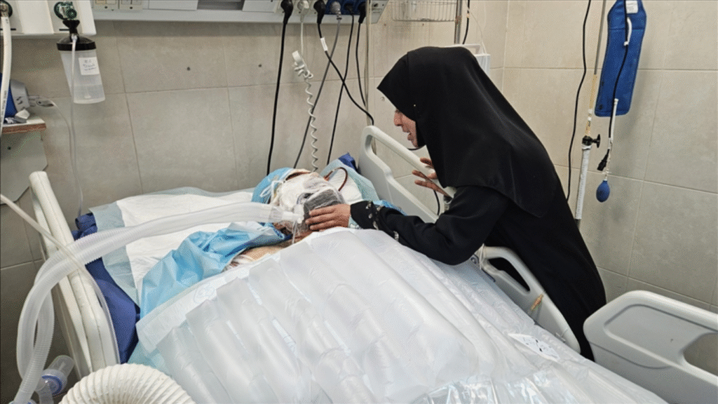 La doctora palestina Alaa al-Najjar visita a su esposo herido Hamdi en la unidad de cuidados intensivos del Hospital Nasser de Khan Younis, Gaza, después de que un ataque aéreo israelí impactara en su casa.