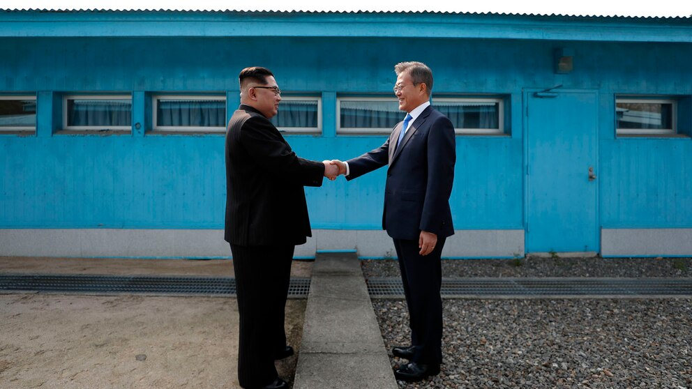 El líder de Corea del Norte, el norcoreano Kim Jong Un (izq.), estrecha la mano del expresidente de Corea del Sur, Moon Jae-in (der.), en la Línea de Demarcación Militar que divide a sus países en 2020