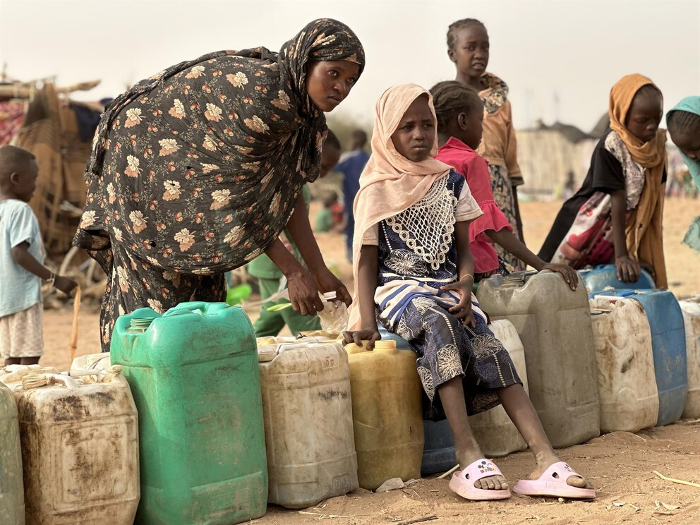 Mujeres y niñas esperan para recolectar agua potable en Sudán