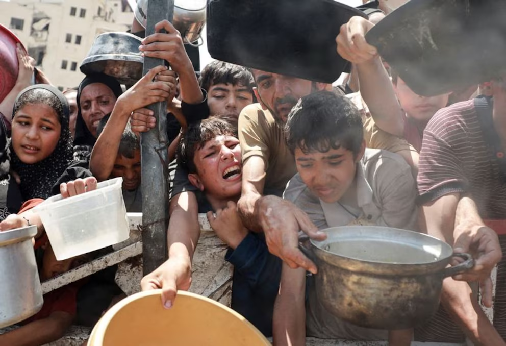 Palestinos esperan a recibir comida de una cocina humanitaria durante una crisis alimentaria, en la ciudad de Gaza. 28 de julio de 2025. (REUTERS)