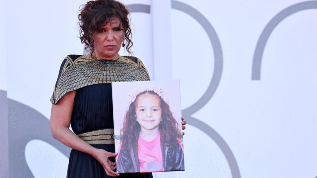 La directora tunecina Kaouther Ben Hania muestra una foto de Hind Rajab a su llegada al estreno de la película “La voz de Hind Rajab” en la 82.ª edición del Festival de Cine de Venecia, en Italia. Foto: EFE