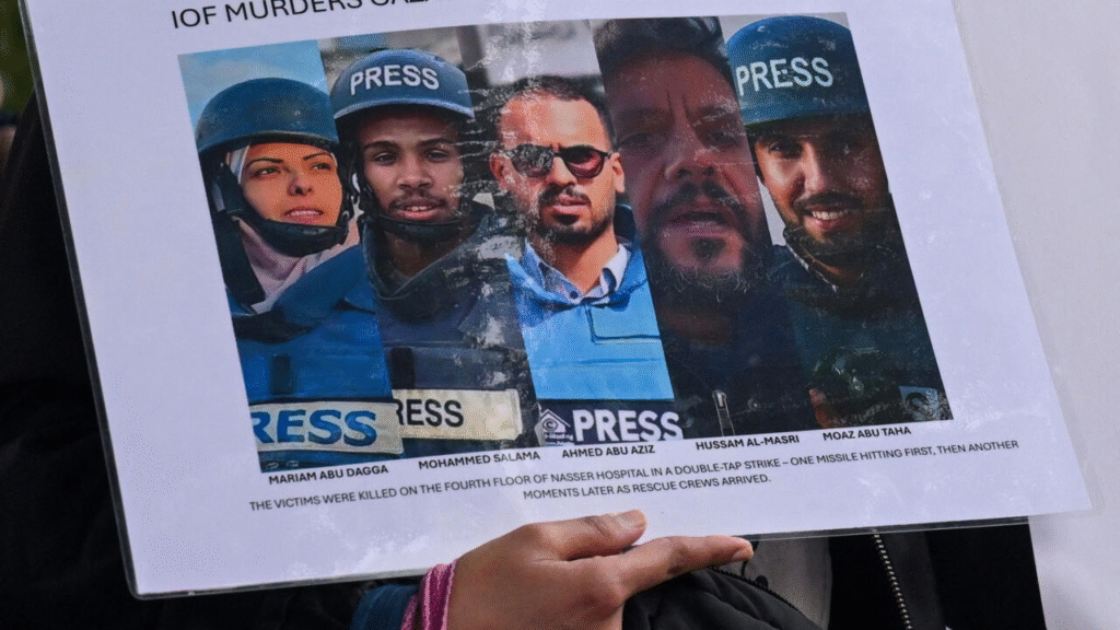 Una persona sostiene un cartel con fotos y nombres de periodistas palestinos asesinados en ataques israelíes contra el hospital Nasser el 25 de agosto de 2025,  Reuters- Jaimi Joy