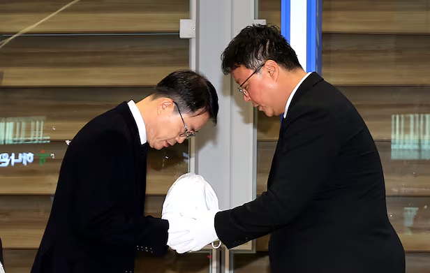 Ahn Jung-man, comandante de la Unidad Móvil de Investigación Criminal de la Policía Provincial de Gyeongbuk (izquierda), recibe en la sala de llegadas de la Terminal 2 del Aeropuerto Internacional de Incheon los restos de Park, un joven surcoreano que falleció tras ser detenido y torturado en Camboya.