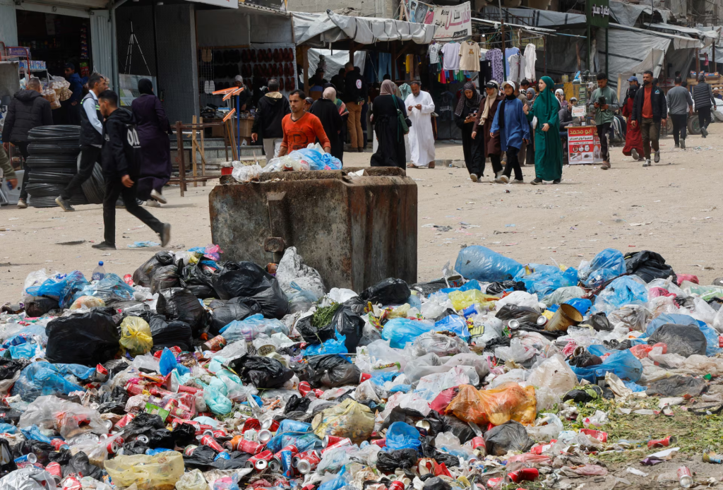 Palestinos caminan junto a montones de basura y desechos cerca de tiendas de campaña para desplazados, en medio de una plaga de roedores, en Khan Younis, en el sur de la Franja de Gaza, el 27 de abril de 2026. REUTERS 