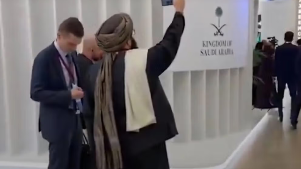 Líder talibán tomando fotografía con su smartphone en un viaje diplomático