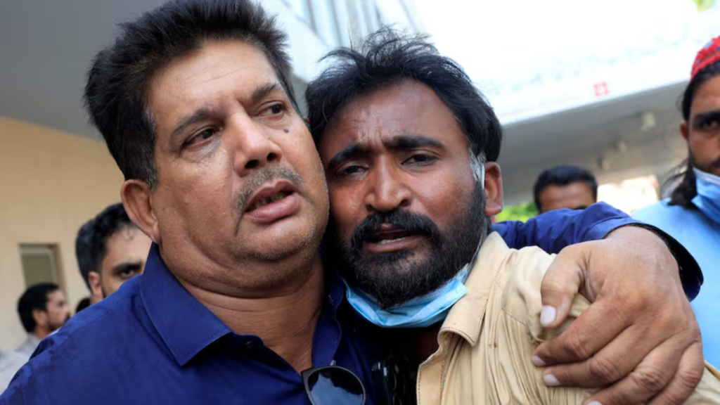 Samiullah, padre de uno de los bebés muertos, es consolado tras conocer la muerte de su hijo en el incendio del hospital en Islamabad.